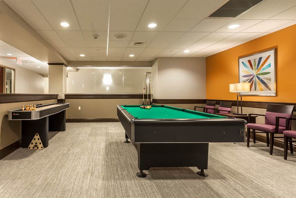 A well-lit game room featuring a billiards table.