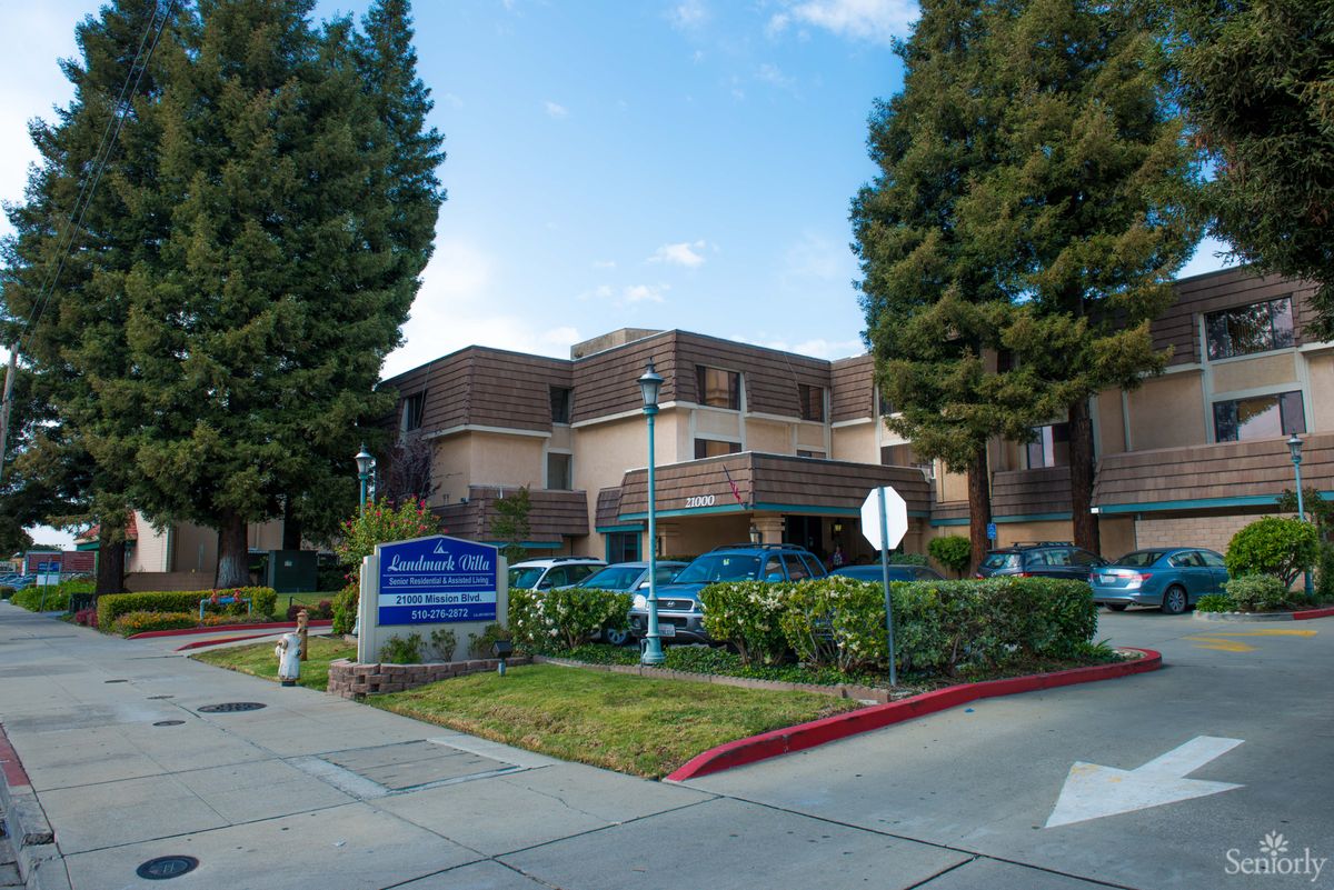 A hospital building surrounded by trees with a clear sky.