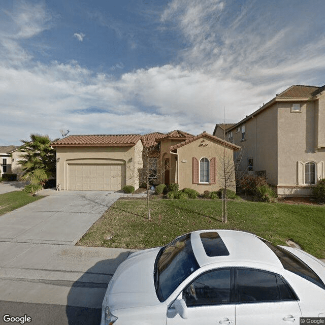 A suburban house with a driveway and car parked in front.