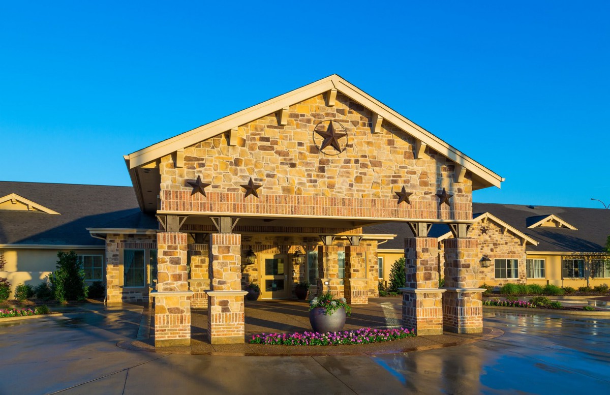 A stone building entrance decorated with star motifs under a clear blue sky.