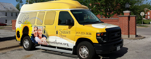 A yellow van with the branding of Sunset Home, featuring contact details.