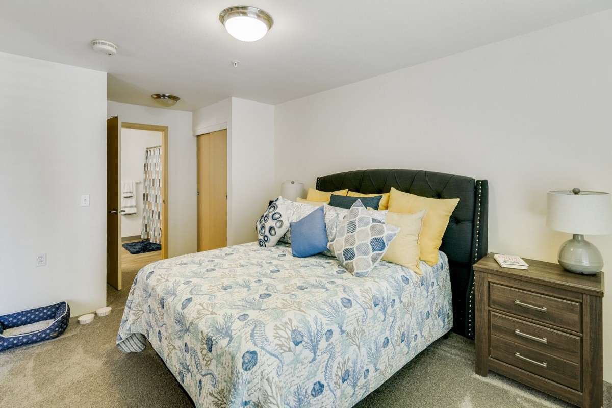 A cozy bedroom with a neatly made bed and decorative pillows.