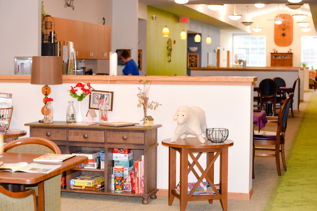 A cozy indoor play area with furniture and toys neatly organized on shelves.
