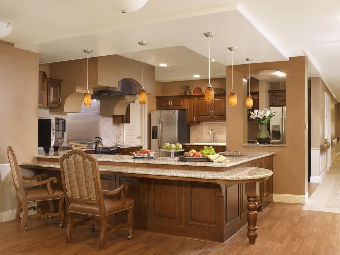 A modern kitchen with wooden cabinets, an island counter, and stainless steel appliances.