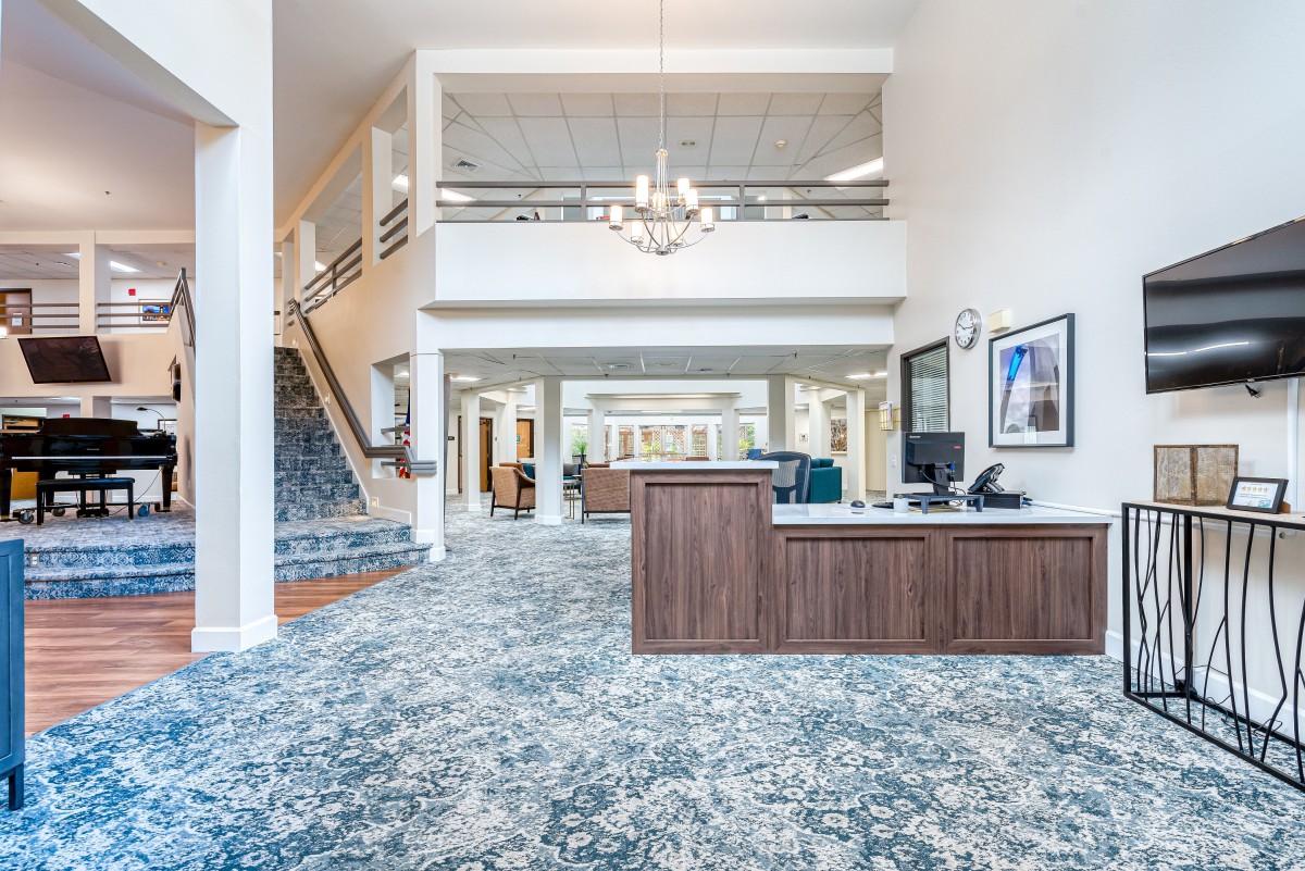 Spacious and elegantly designed lobby with a reception desk and chandelier.