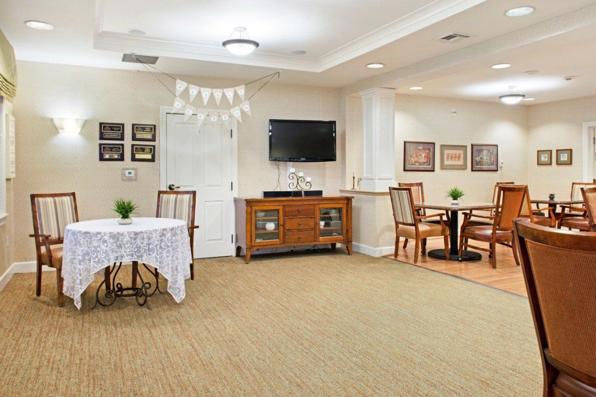 A well-decorated living room with tables, chairs, a television, and various decorative elements.
