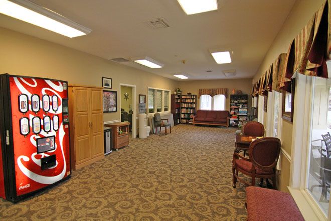 A spacious waiting room with a vending machine and comfortable seating.
