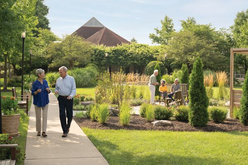 A couple enjoys a stroll through a beautifully landscaped garden, surrounded by greenery and fellow visitors.