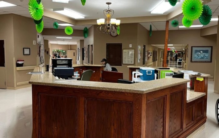 A reception area with wooden desk and office equipment.