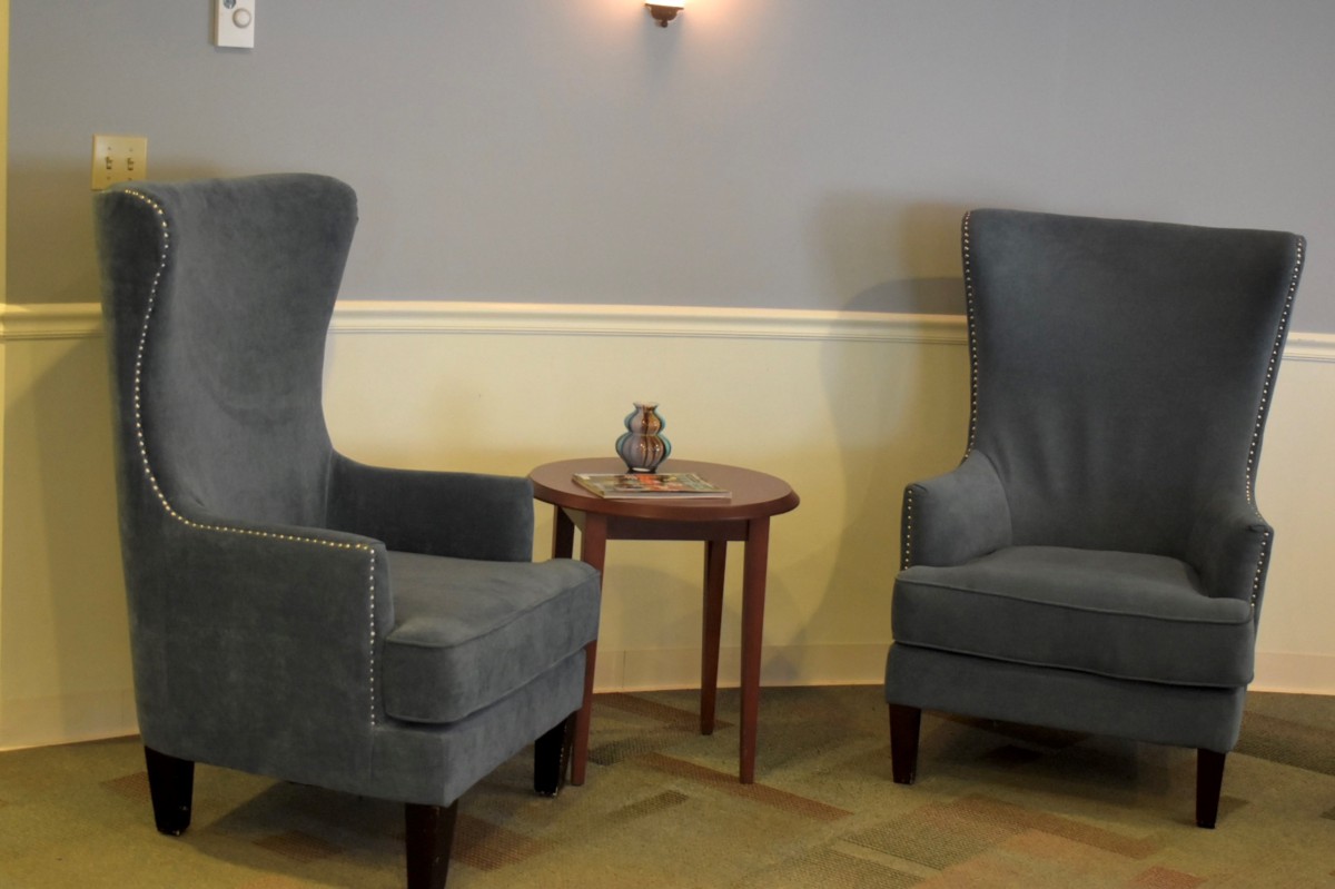 A cozy seating area with two high-backed chairs and a small round table between them.