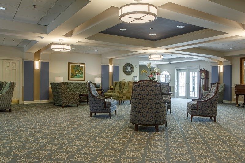 A spacious and well-lit lobby featuring comfortable seating with elegant carpet and ceiling designs.