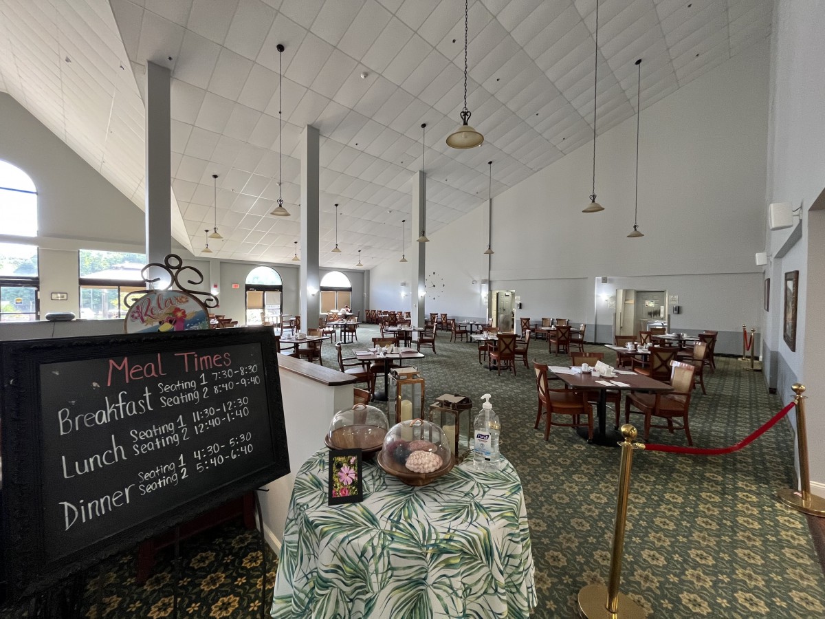 An empty restaurant dining area with neatly arranged tables and a menu board displaying the day's specials.