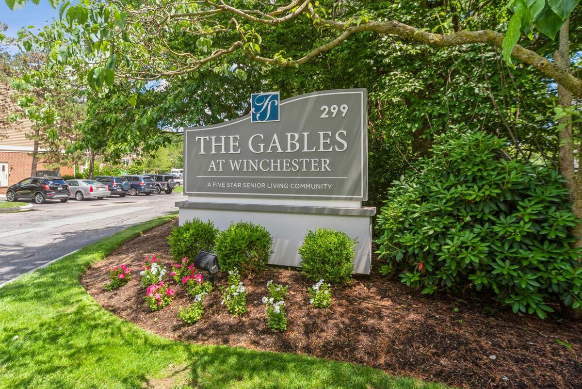 Sign for The Gables at Winchester surrounded by lush garden.