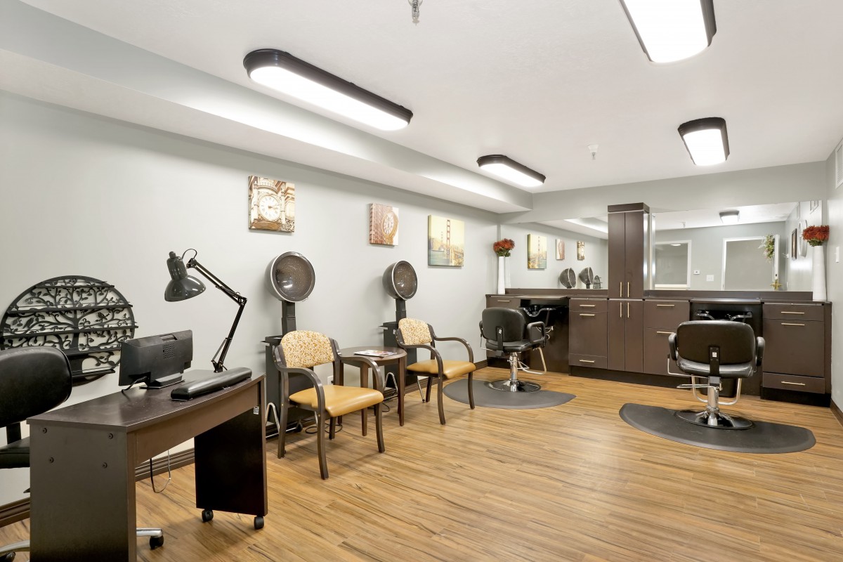 A modern hair salon interior with chairs, mirrors, and hair dryers.