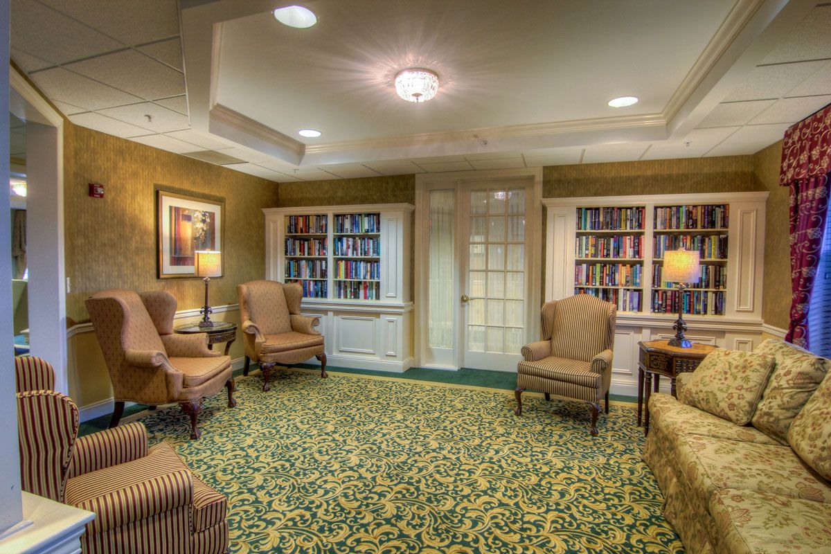 A cozy library reading room with armchairs and bookshelves.