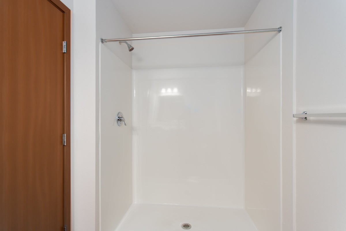 A minimalist white shower area with a simple design.