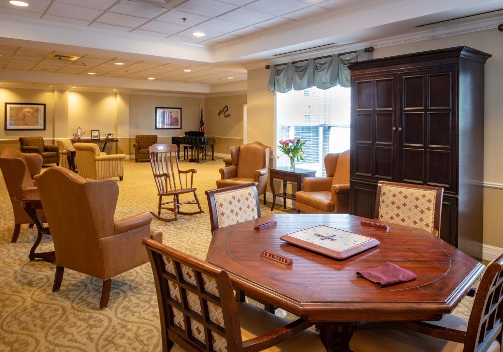 A cozy and well-lit living room with multiple seating areas, a large table, and comfortable armchairs.