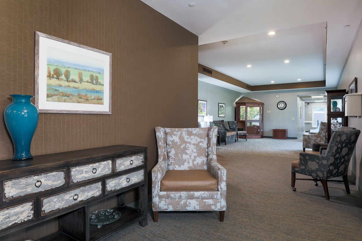 A cozy living room with an armchair, console table, and artwork on the wall.