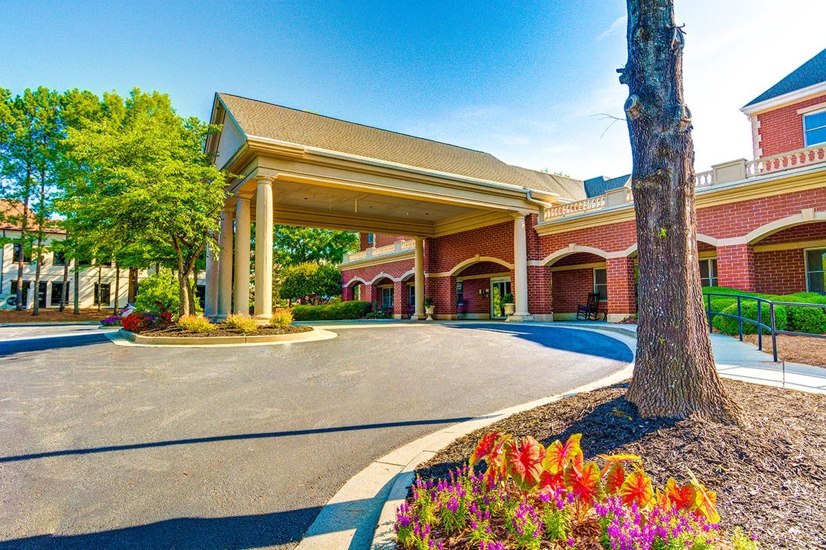 Elegant building entrance with columns and landscaping.