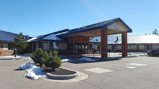 A modern commercial building with a blue roof and clear sky in the background.