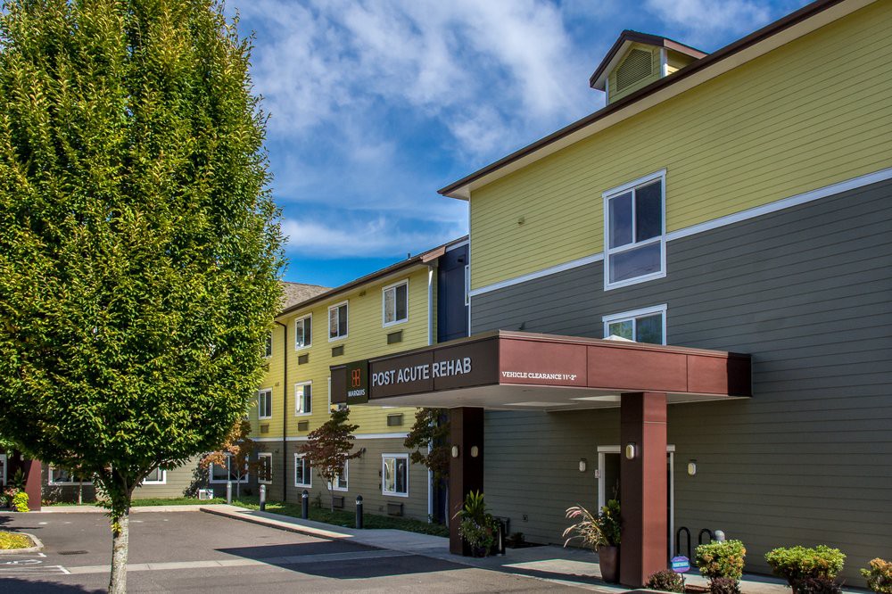 A modern hotel building with a welcoming entrance and neatly maintained surroundings.