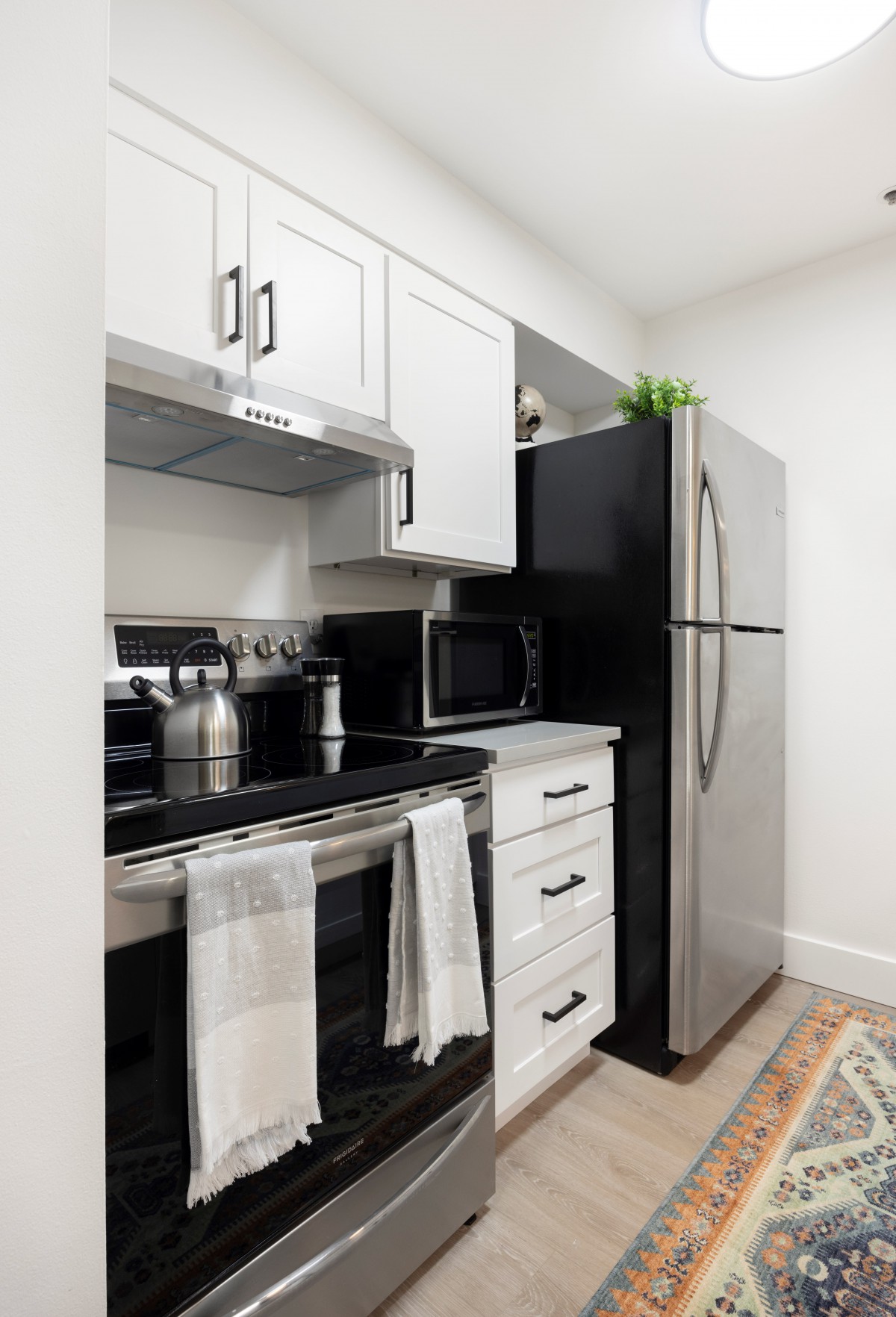 A modern kitchen with sleek appliances and white cabinetry.