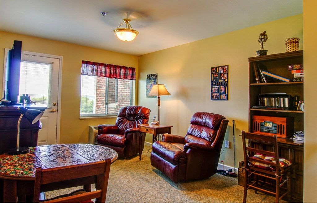 Cozy living room with comfortable armchairs and a bookshelf.