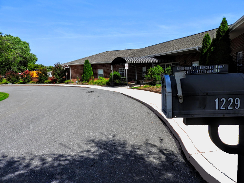 A serene residential scene featuring a curved road leading to a well-maintained home with a mailbox in the foreground.