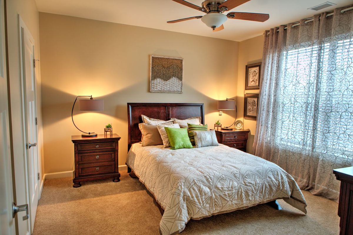 A cozy bedroom with a neatly made bed and stylish decor.