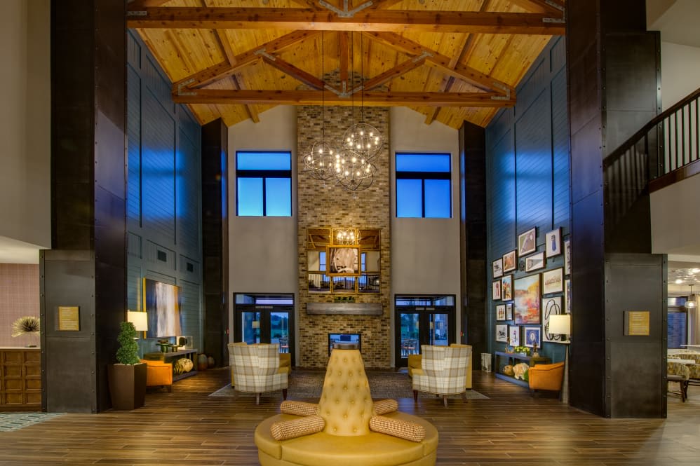 Luxurious lobby with high wooden ceilings and a central fireplace.