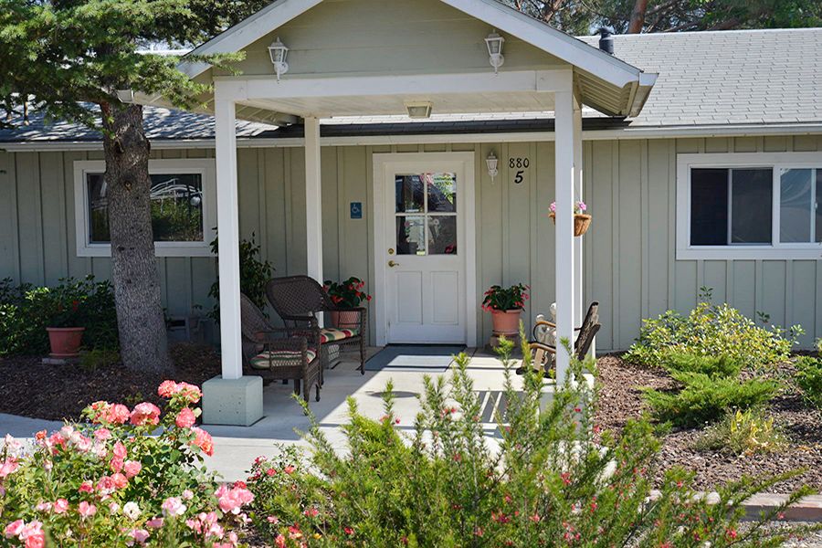 A charming house with a small porch and vibrant garden.