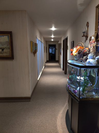 A well-lit indoor hallway featuring a decorative fish tank and artwork on the walls.