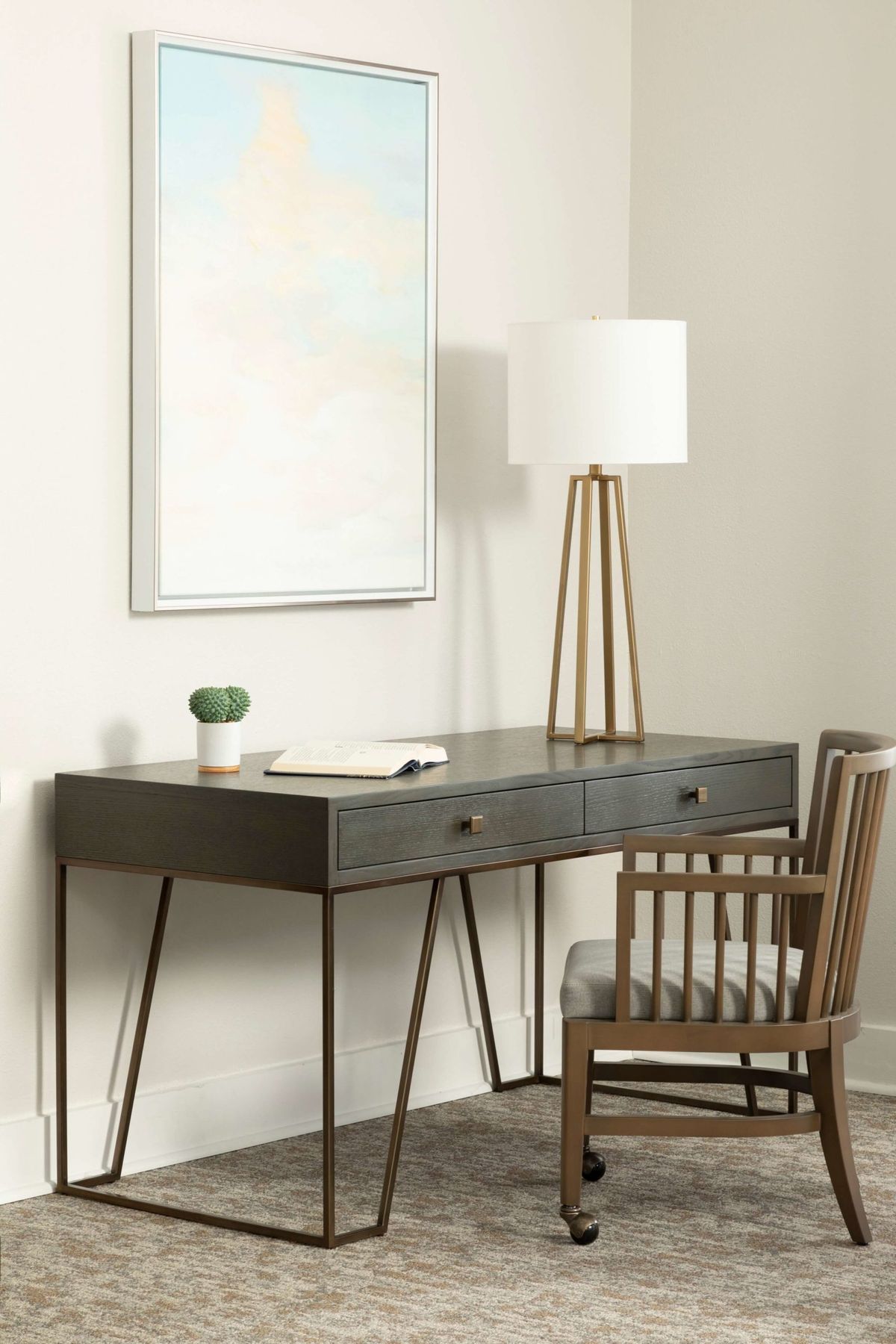 A minimalist home office setup with a sleek desk, chair, and floor lamp.