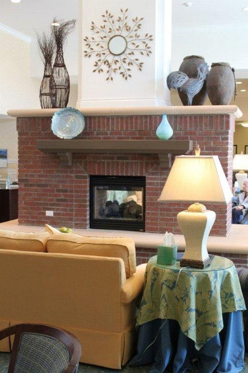 A cozy living room with a brick fireplace, sofa, and decorative elements.
