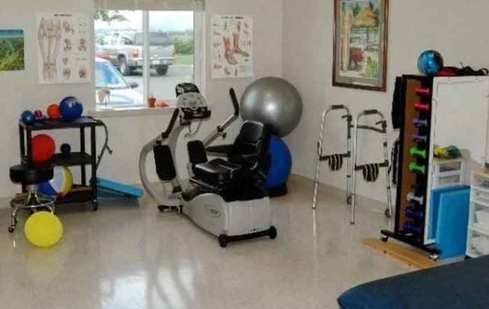 A physical therapy room equipped with various exercise machines and tools for rehabilitation.