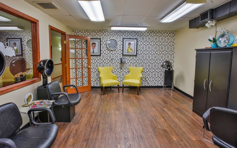 Cozy salon waiting area with stylish decor and comfortable seating.