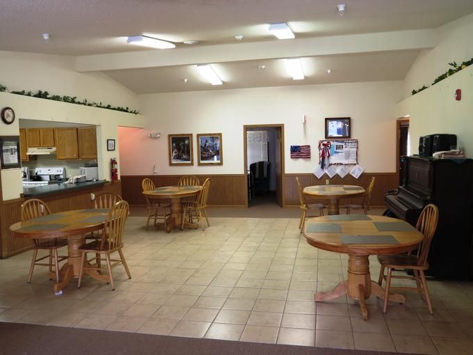 A cozy dining area with wooden tables and chairs, decorated with framed photographs.