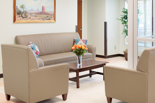A cozy waiting area featuring comfortable seating and a touch of decorative flowers.