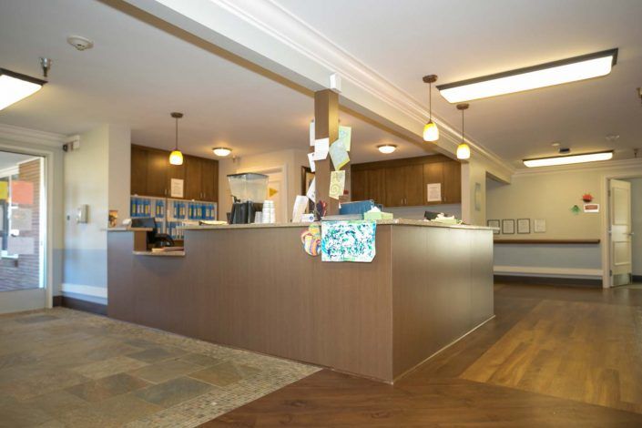 A modern reception area with a wooden desk and overhead lighting.