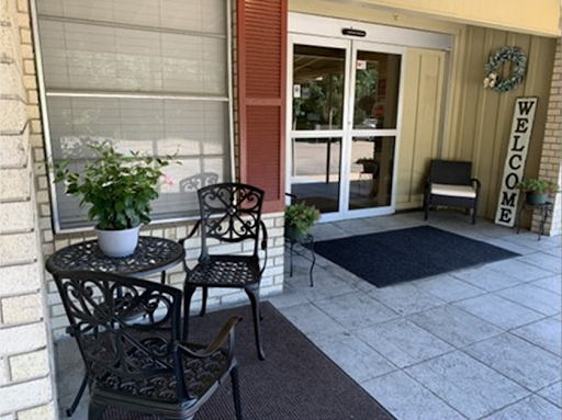 A cozy entrance with chairs and a table, perfect for relaxing outdoors.