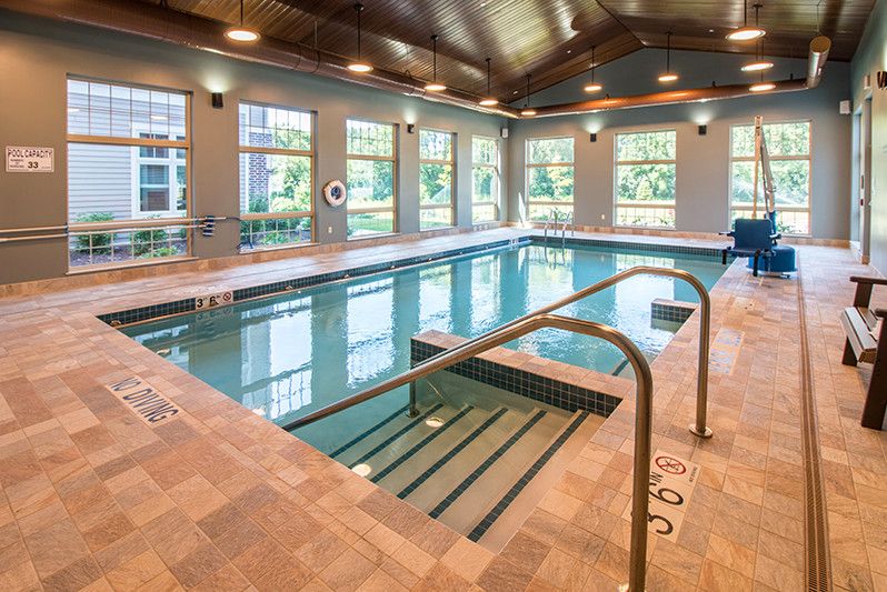 A luxurious indoor swimming pool area with natural lighting and elegant design.