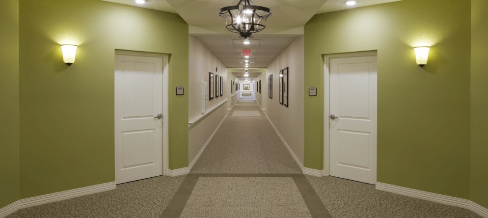 A well-lit hallway with green accents and multiple doors.