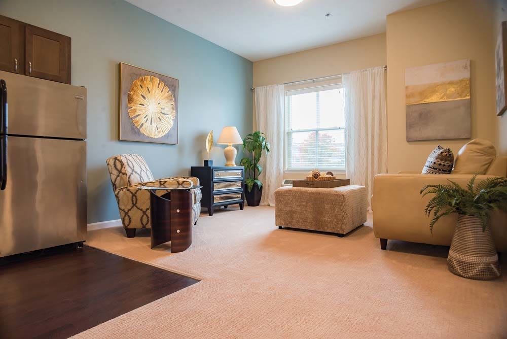 A cozy living room featuring elegant furniture and stylish decor, with natural light streaming in through the window.