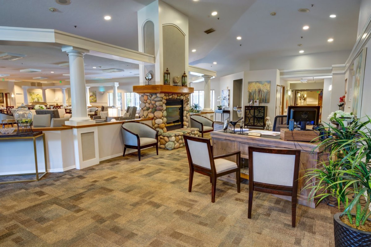 A spacious and elegantly decorated lounge featuring a central fireplace and comfortable seating.