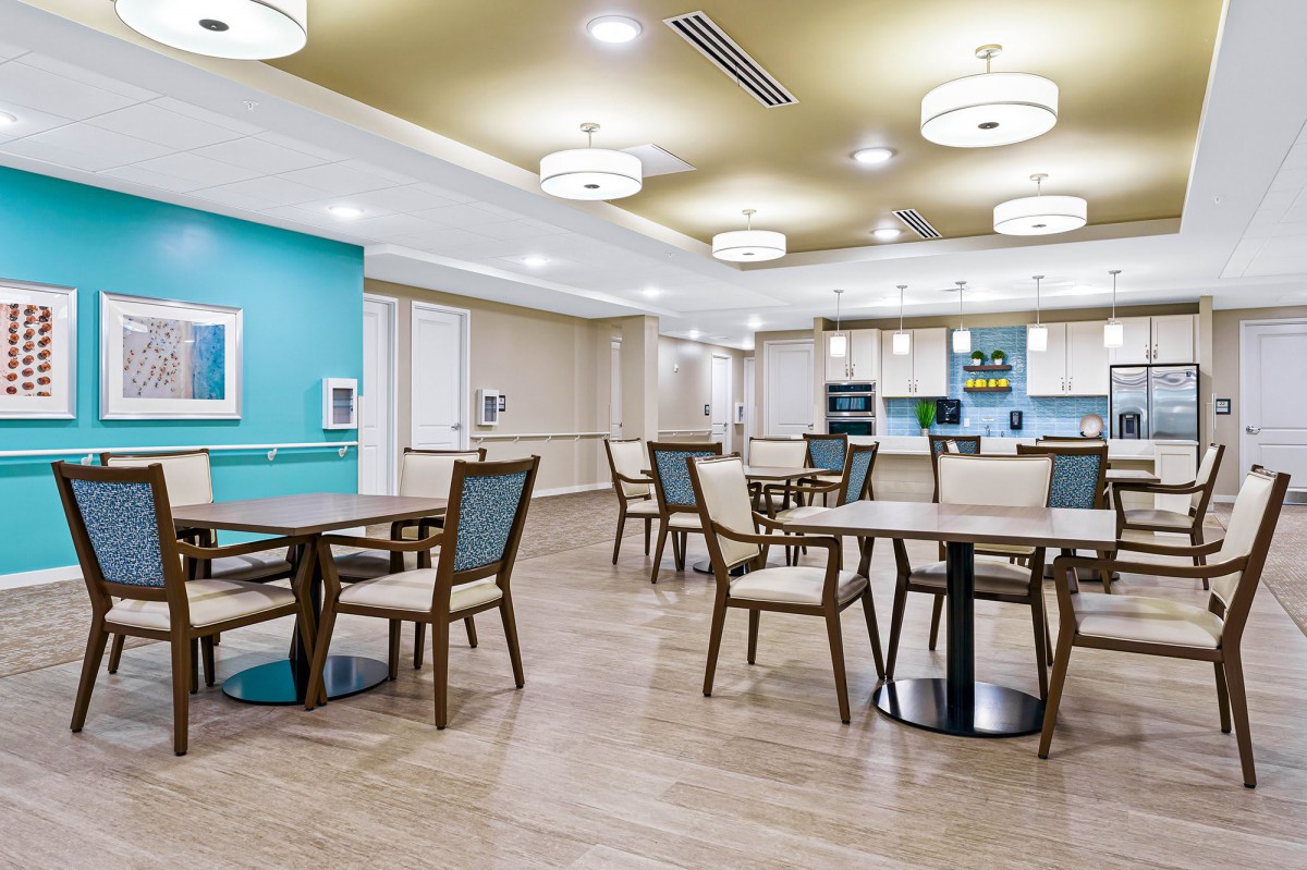 A modern dining area with wooden flooring and contemporary lighting.