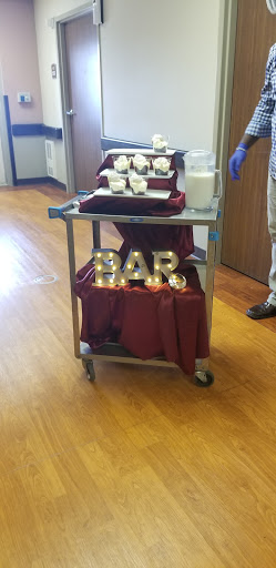 A beautifully arranged cart featuring snacks and a decorative BAR sign, ready for an event.