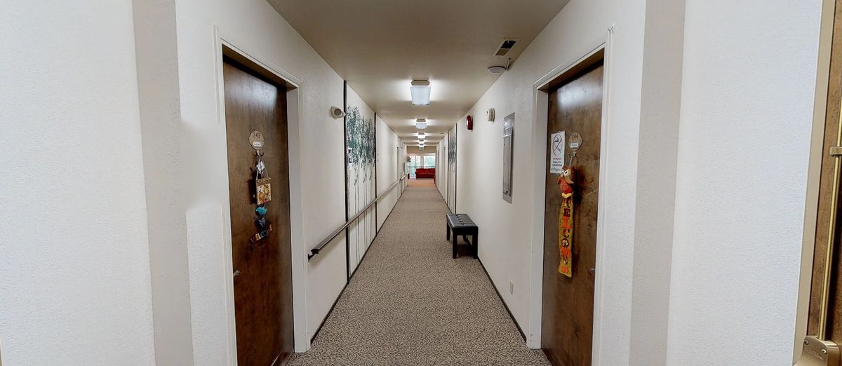 A well-lit hallway with multiple doors and decorations on the walls.