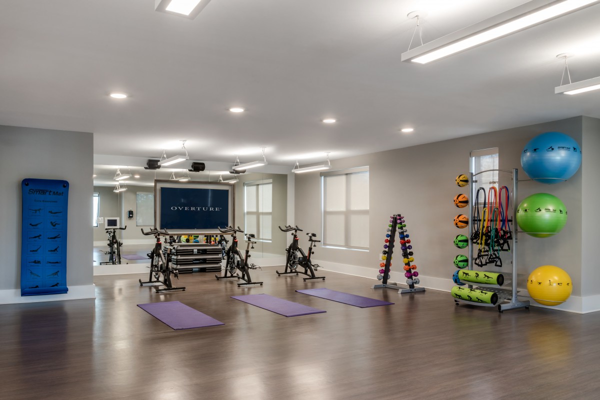 A modern gym with exercise bikes, yoga mats, and a variety of fitness equipment.