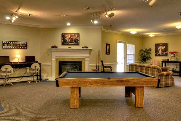 A cozy living room with a pool table and fireplace.