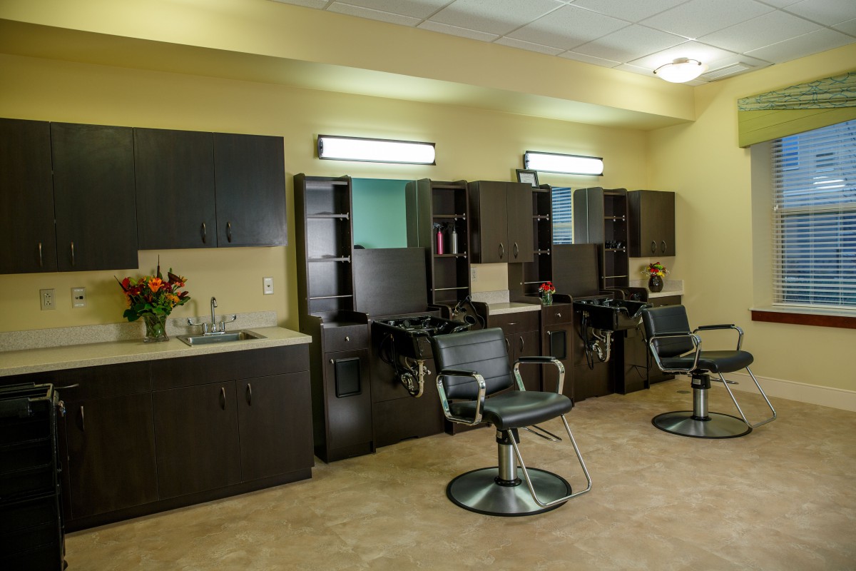 An empty hair salon with styling chairs, mirrors, and sinks.